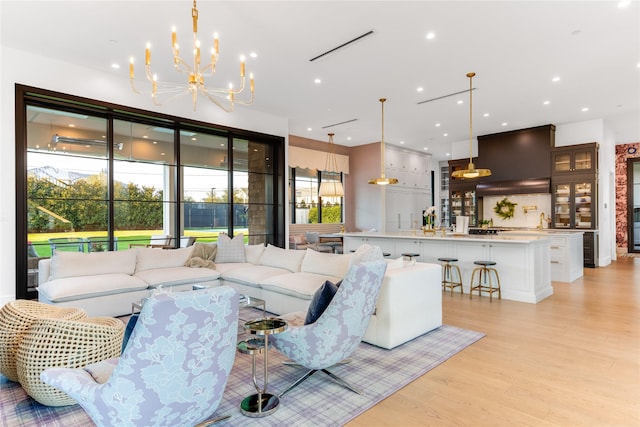 living room with a notable chandelier and light hardwood / wood-style floors