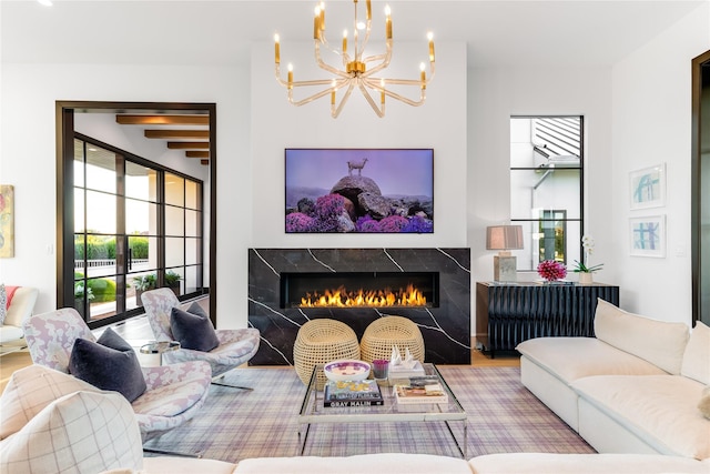 living room featuring radiator, an inviting chandelier, beamed ceiling, a high end fireplace, and hardwood / wood-style flooring