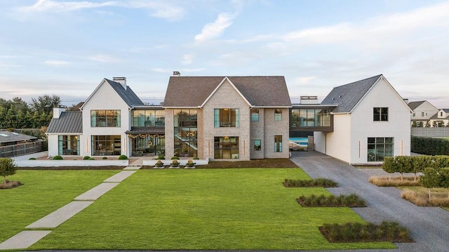 view of front of house with a balcony and a front lawn