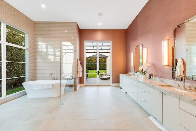 bathroom featuring tile patterned floors, a washtub, and vanity