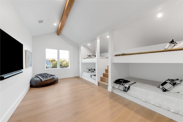 bedroom featuring lofted ceiling with beams and light hardwood / wood-style flooring