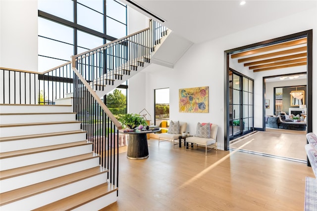 stairway featuring beam ceiling and hardwood / wood-style flooring