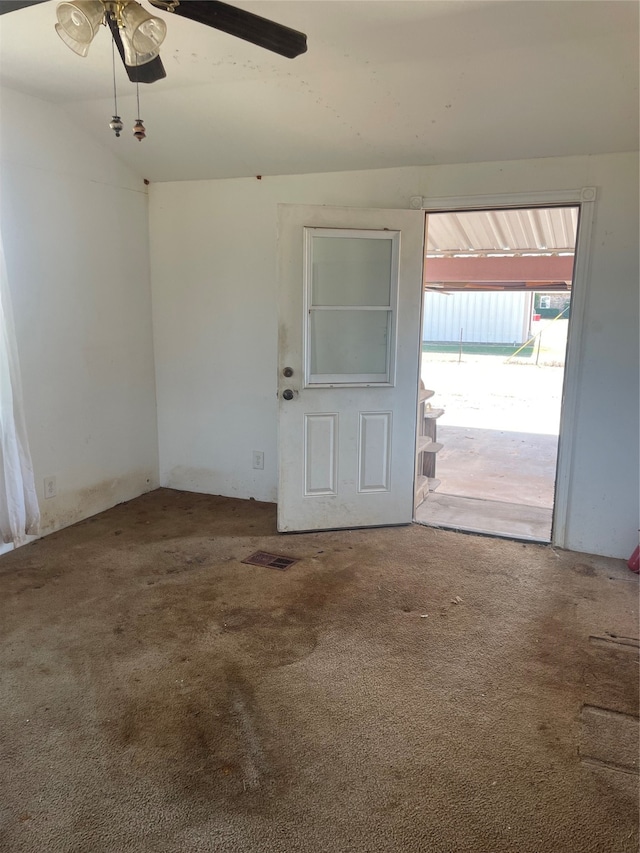 carpeted spare room featuring lofted ceiling and ceiling fan