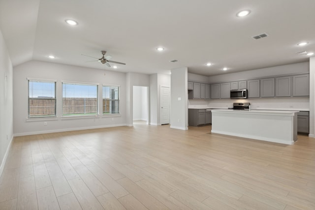 kitchen with ceiling fan, visible vents, stainless steel appliances, open floor plan, and gray cabinets