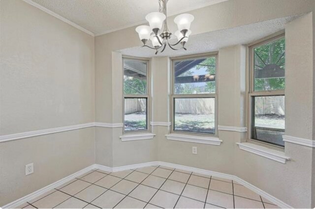 tiled spare room featuring an inviting chandelier, a textured ceiling, and crown molding