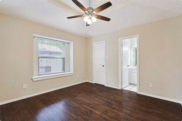 interior space with a textured ceiling, ensuite bath, ceiling fan, and hardwood / wood-style flooring