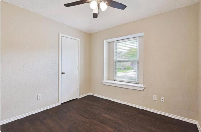 empty room featuring ceiling fan and dark hardwood / wood-style floors