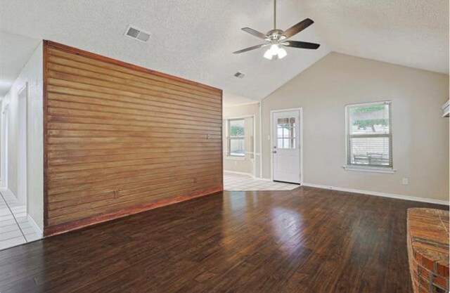 unfurnished living room with lofted ceiling, a textured ceiling, hardwood / wood-style flooring, and ceiling fan