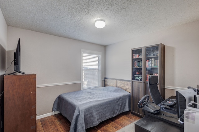 bedroom with hardwood / wood-style flooring and a textured ceiling