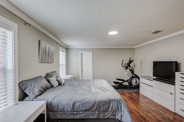 bedroom featuring dark wood-type flooring, crown molding, and a textured ceiling