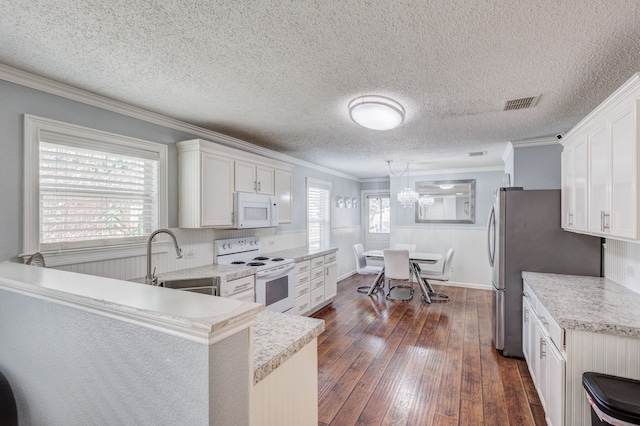 kitchen with white appliances, sink, dark hardwood / wood-style flooring, white cabinets, and ornamental molding