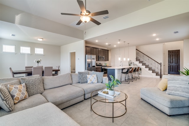 tiled living room featuring ceiling fan and sink