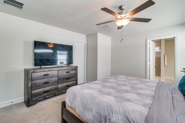 bedroom featuring ceiling fan, ensuite bathroom, and light carpet