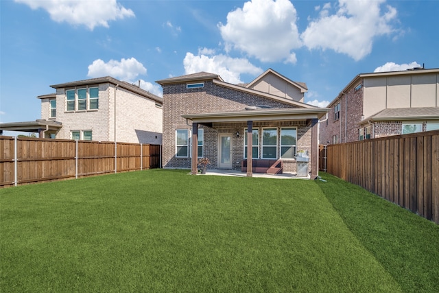 rear view of house featuring a lawn and a patio