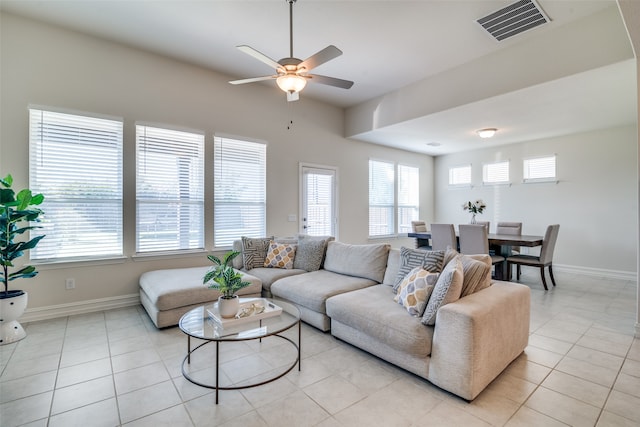 tiled living room with ceiling fan and a healthy amount of sunlight