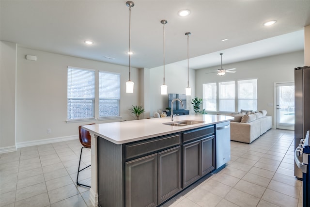 kitchen featuring a kitchen island with sink, sink, stainless steel dishwasher, ceiling fan, and light tile patterned floors