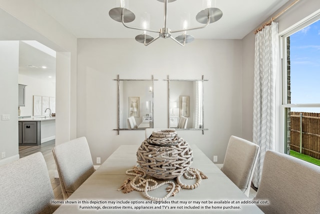 dining space featuring wood-type flooring and a notable chandelier