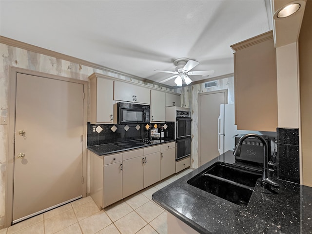 kitchen featuring light tile patterned flooring, sink, decorative backsplash, black appliances, and ceiling fan