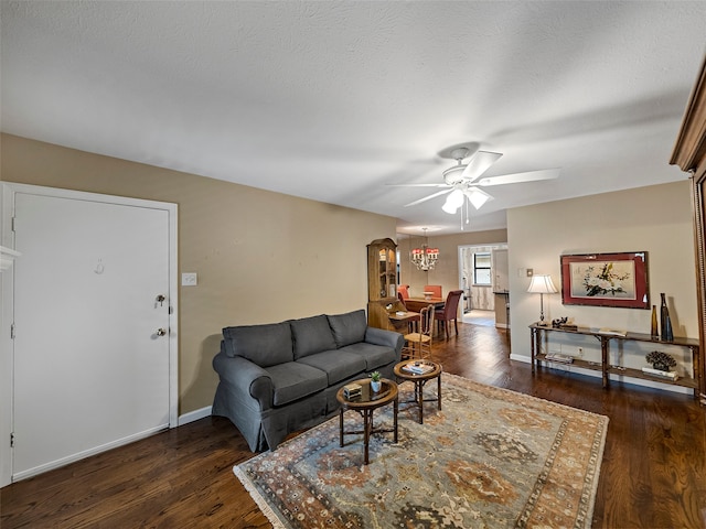 living room featuring ceiling fan, a textured ceiling, and dark hardwood / wood-style flooring