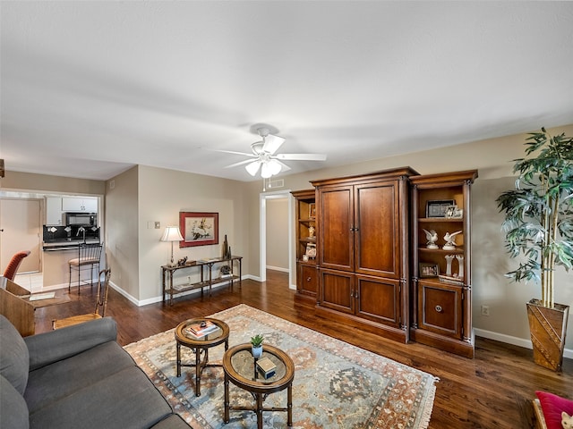 living room with ceiling fan and dark hardwood / wood-style flooring