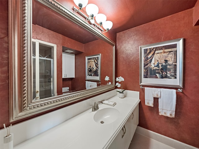 bathroom featuring tile patterned flooring, walk in shower, and vanity