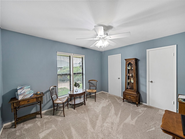 living area featuring ceiling fan and light colored carpet