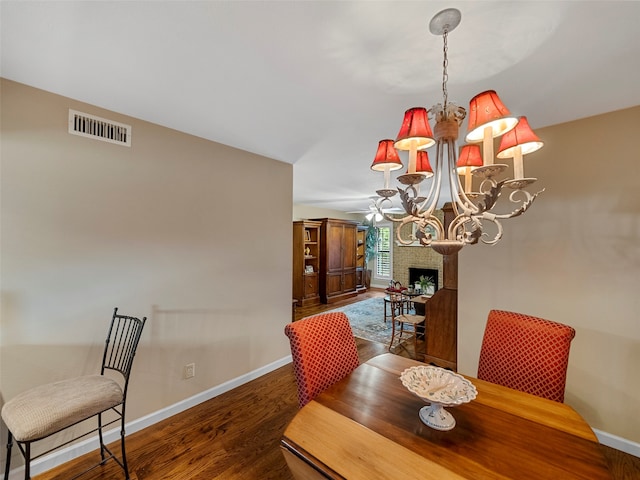 dining room featuring ceiling fan with notable chandelier and dark hardwood / wood-style flooring