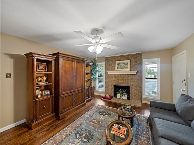 living room featuring ceiling fan, a fireplace, and dark hardwood / wood-style flooring