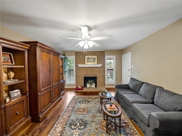 living room with a brick fireplace, ceiling fan, and dark hardwood / wood-style floors