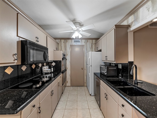 kitchen with tasteful backsplash, light tile patterned floors, black appliances, dark stone counters, and sink