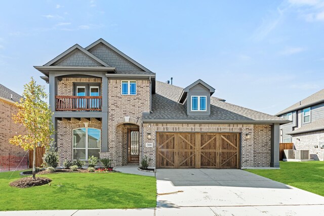 view of front of property with a garage, a balcony, and a front lawn