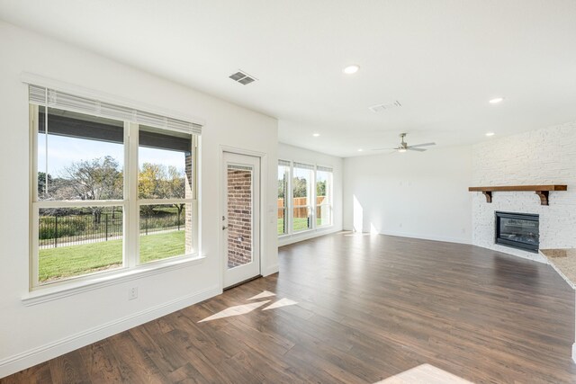 unfurnished living room featuring a fireplace, ceiling fan, and dark wood-type flooring