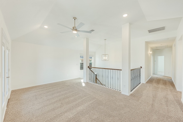 spare room with ceiling fan, light carpet, and vaulted ceiling