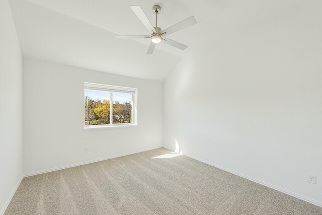 unfurnished room featuring ceiling fan, light colored carpet, and vaulted ceiling