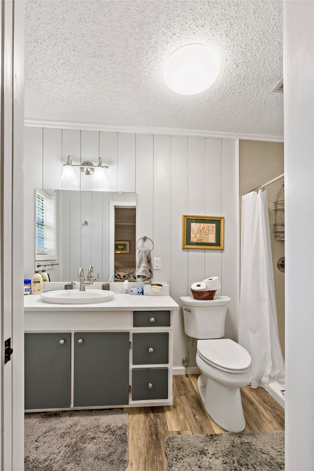 bathroom featuring vanity, toilet, curtained shower, a textured ceiling, and hardwood / wood-style floors