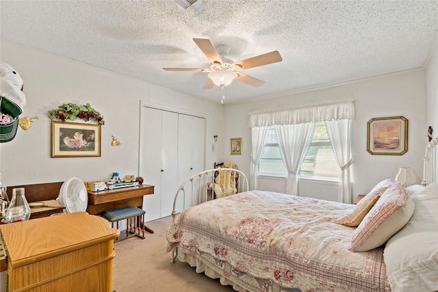 carpeted bedroom featuring ceiling fan, a textured ceiling, a closet, and crown molding