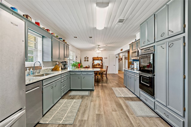 kitchen featuring wood ceiling, kitchen peninsula, appliances with stainless steel finishes, and sink