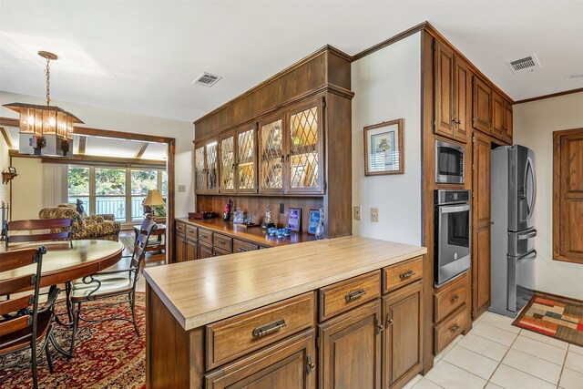 kitchen featuring pendant lighting, light tile patterned flooring, kitchen peninsula, stainless steel appliances, and a notable chandelier