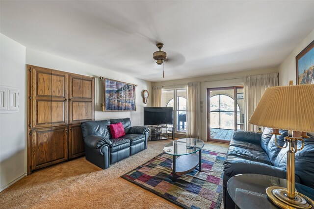 carpeted living room with ceiling fan