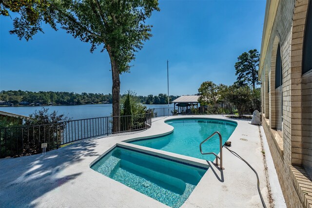 view of swimming pool featuring a water view and a patio area