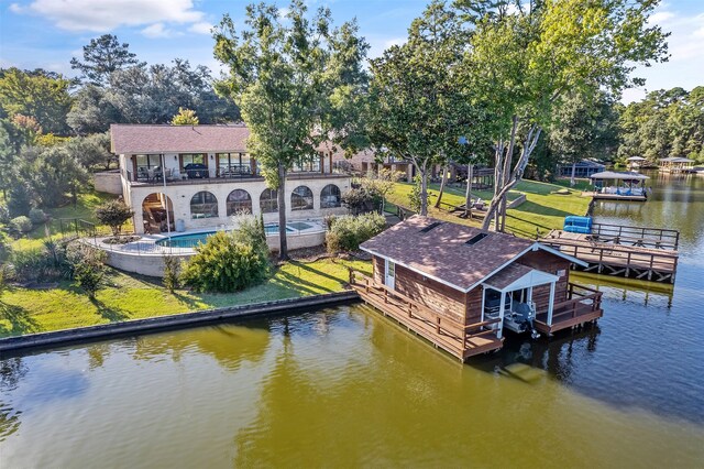 view of dock with a water view, a yard, and a balcony