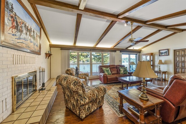 living room featuring wood-type flooring, a fireplace, lofted ceiling with beams, and ceiling fan