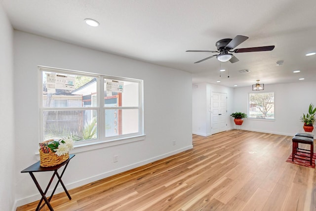 living area with light hardwood / wood-style floors and ceiling fan