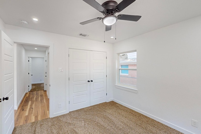 unfurnished bedroom featuring ceiling fan, a closet, and carpet flooring