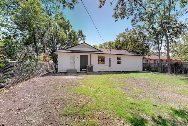 back of house with a yard and central AC