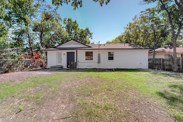 back of house featuring a yard and central AC unit