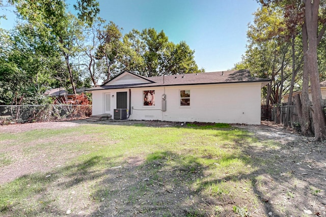 rear view of house featuring a yard and central AC unit