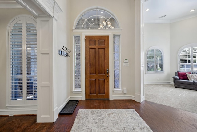 entrance foyer with crown molding and dark hardwood / wood-style floors