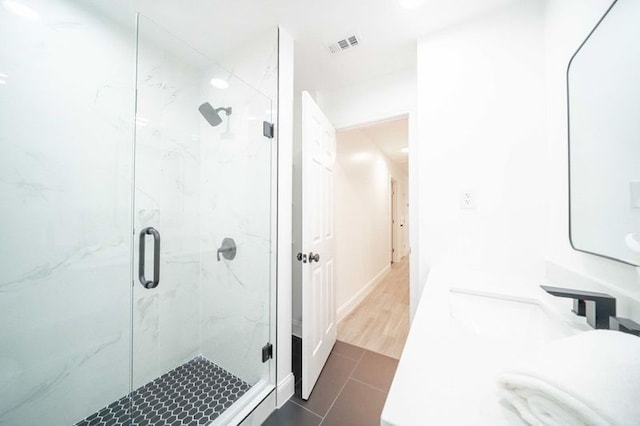 bathroom featuring hardwood / wood-style flooring, vanity, and a shower with shower door