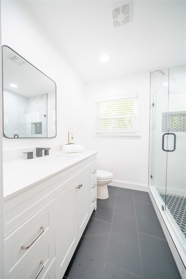 bathroom featuring tile patterned flooring, vanity, toilet, and an enclosed shower